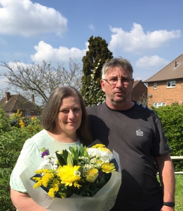 two-people-outside-one-of-them-is-holding-a-large-bouqet-of-spring-flowers