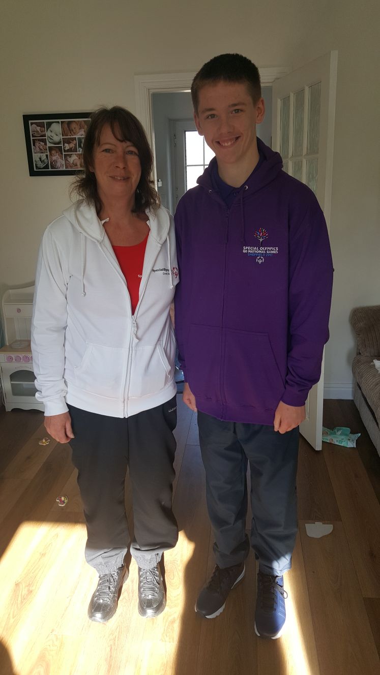 two happy people standing in a well lit living room