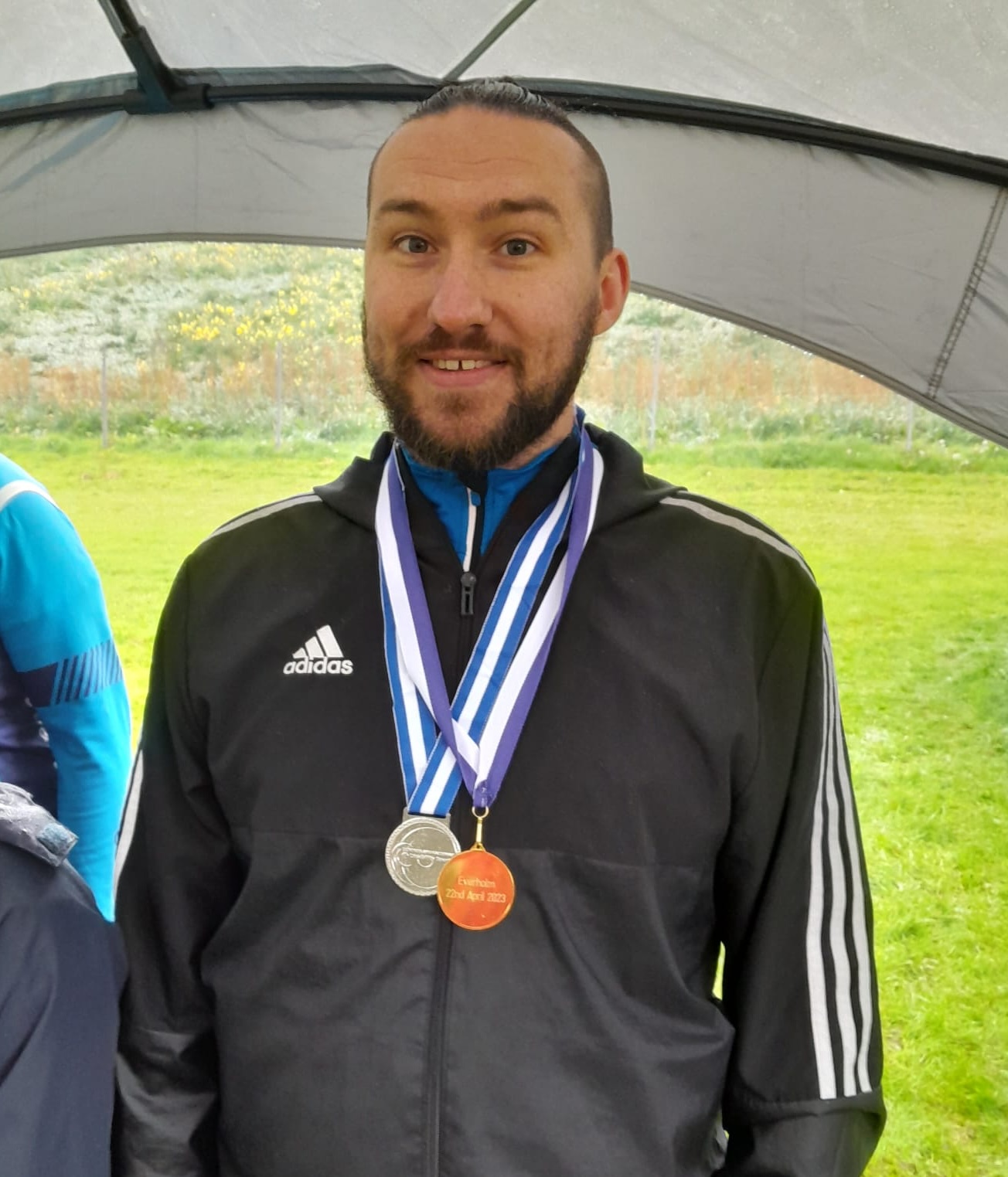 a proud person with some medals they have just won around their neck