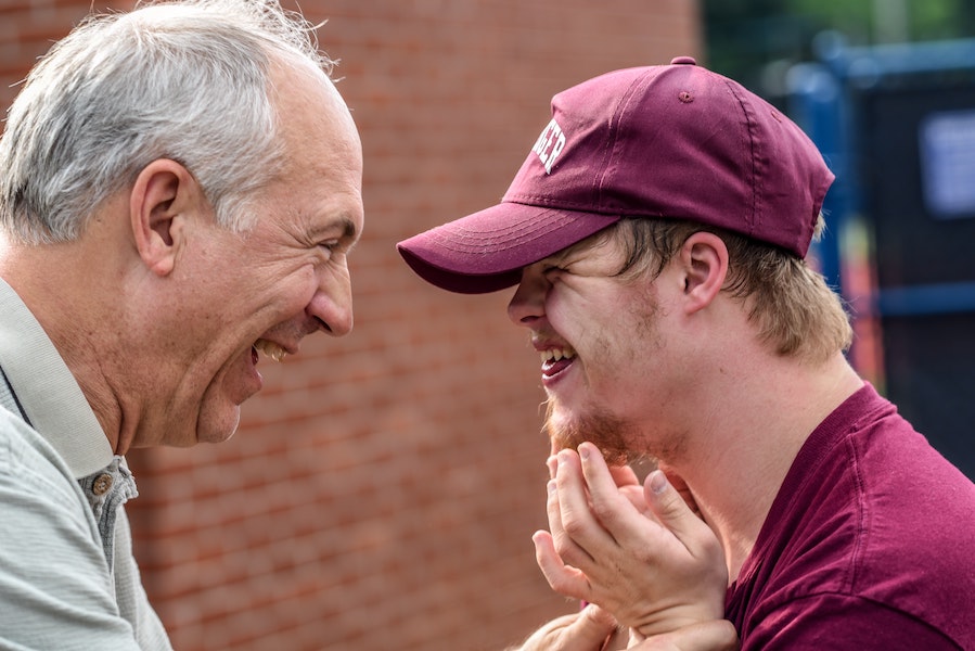 very happy older man and young man facing each other