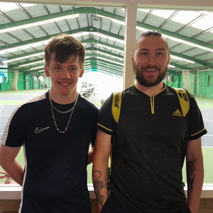 two happy people standing side by side in a sports centre